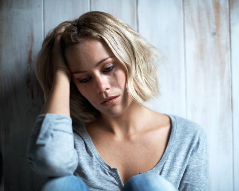 chica sentada llorando.